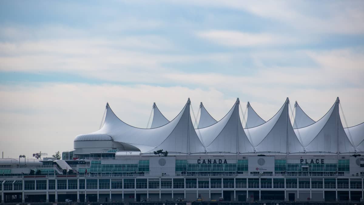 Vancouver, British Columbia, Canada — Iconic Canada Place building with its sail-like roof in Vancouver, BC against a blue sky.
