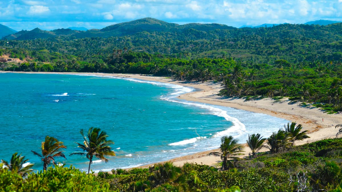 Puerto Plata, Dominican Republic — A view of a beach with a boat in the water