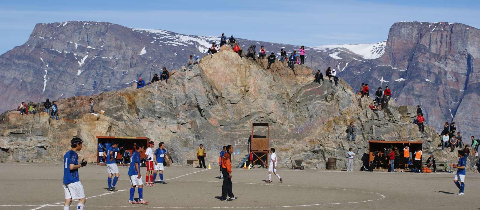soccer field mountains people