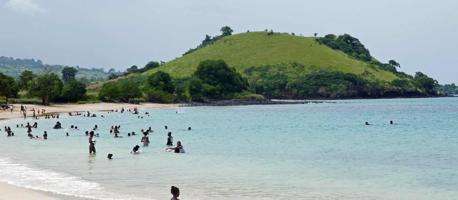 beach coastline hill ocean people swimming