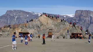 soccer field mountains people