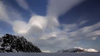 snowy mountains dramatic clouds