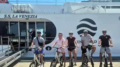 A group of five people with bicycles in front of a ship - SS La Venezia, Uniworld