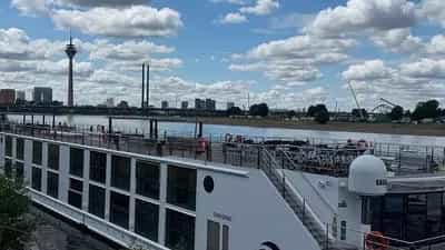 A river cruise ship is docked with a city skyline in the background - SS Victoria, Uniworld