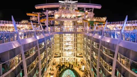 A cruise ship's interior atrium with water slides at night - Symphony Of The Seas, Royal Caribbean