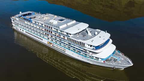 A river cruise ship sails on dark water - American Spirit, American Cruise Lines