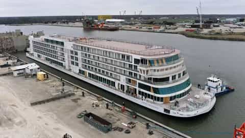 A large white cruise ship is docked at a shipyard - Viking Mississippi, Viking River Cruises
