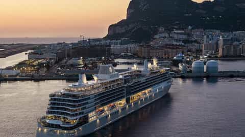 A large cruise ship is docked in a port at sunset - Viking Sea, Silversea Cruises