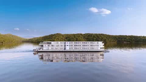 A river cruise ship sails on calm water - Viking Skadi, Viking River Cruises