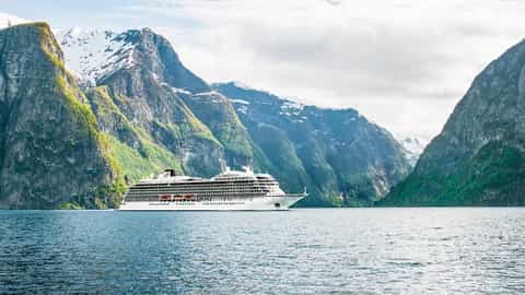 A cruise ship sails through a scenic fjord - Viking Sky, Viking Cruises