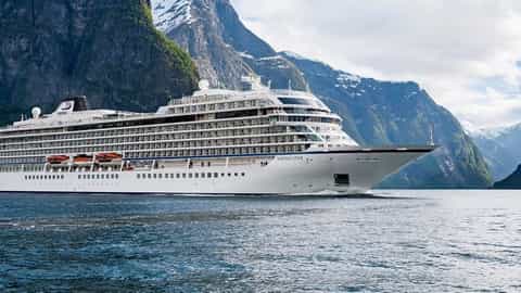 A large cruise ship sails through a scenic fjord - Viking Star, Viking Cruises