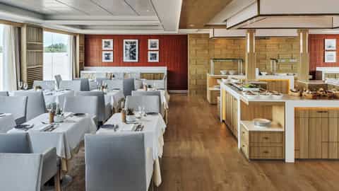 A dining room with tables set and a buffet station - Viking Tonle, Viking River Cruises