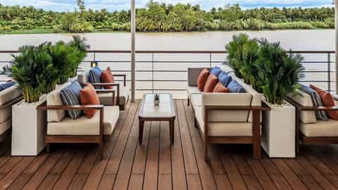 Outdoor seating area with sofas and plants overlooking a river - Viking Tonle, Viking River Cruises