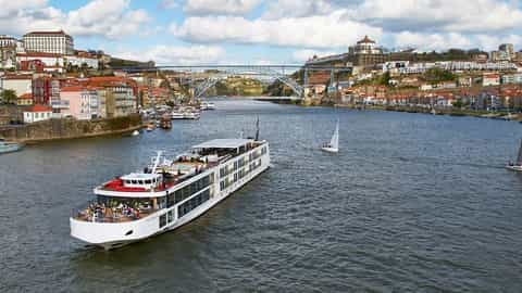 A river ship sails past a European city on a sunny day - VIVA Moments, Viking River Cruises