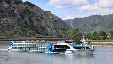 A river cruise ship sails on a wide river with green hills - VIVA Tiara, Viva Cruises
