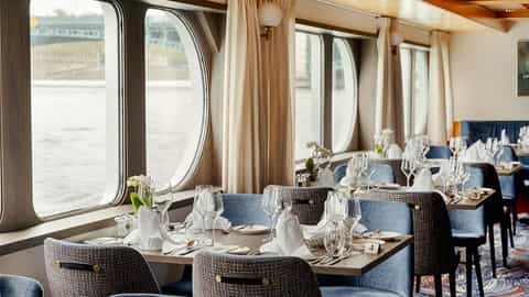 Set dining tables with place settings and water views - VIVA Voyage, Viva Cruises