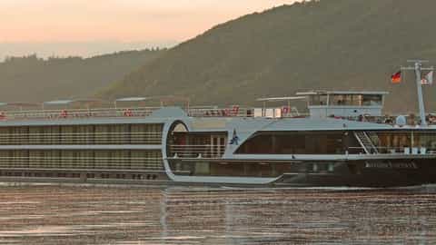 A river cruise ship sails on the water at sunset - Avalon Poetry II, Avalon Waterways