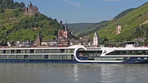 A river ship sails past a scenic town and castle - Avalon Tranquility II, Avalon Waterways