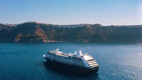 A cruise ship sails in the blue sea near Santorini - Azamara Journey, Azamara Cruises