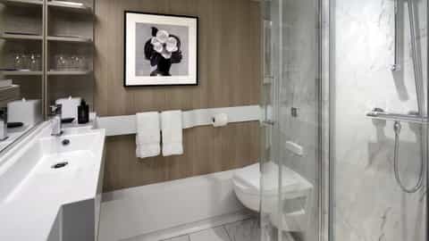 A modern bathroom with a sink, toilet, and shower - Celebrity Apex, Celebrity Cruises