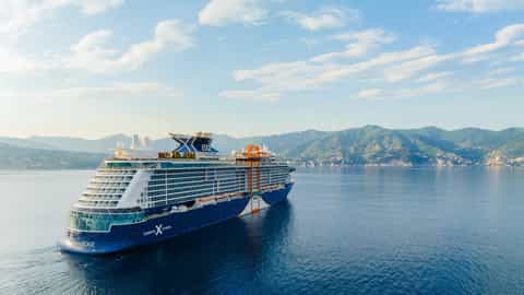 A large cruise ship sails on the sea near mountains - Celebrity Edge, Celebrity Cruises