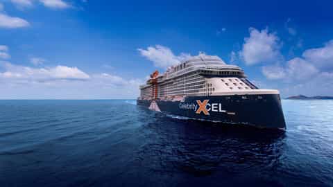 A large cruise ship sails on the ocean under a blue sky - Celebrity Xcel, Celebrity Cruises