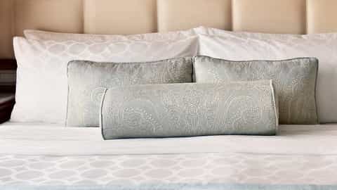 A neatly made bed with decorative pillows - Discovery Princess, Princess Cruises