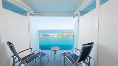Two lounge chairs and a table on a balcony overlooking the ocean - Adventure Of The Seas, Royal Caribbean