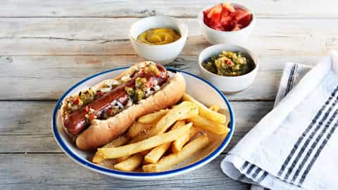 A hot dog with toppings and french fries on a plate - Emerald Princess, Princess Cruises