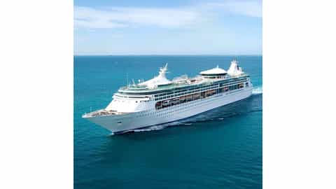 A large cruise ship sails on a bright blue ocean - Enchantment Of The Seas, Royal Caribbean