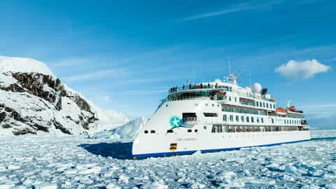 A ship sails through a field of ice - Greg Mortimer, Aurora Expeditions