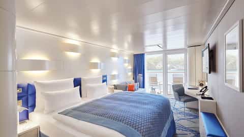 A modern cruise ship suite with a bed and balcony view - Hanseatic Spirit, Hapag-Lloyd Cruises