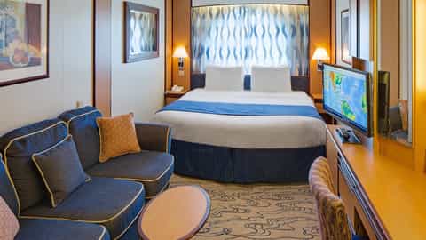 A cruise ship stateroom with a bed and sofa - Jewel Of The Seas, Royal Caribbean