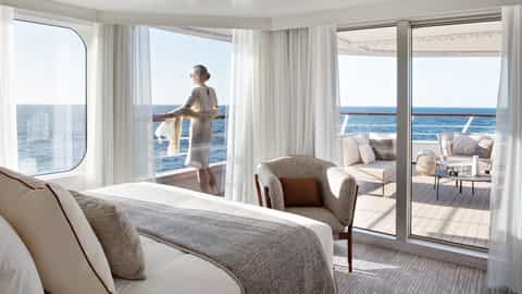 Woman on a balcony looking out at the ocean - Le Bougainville, Ponant Cruises