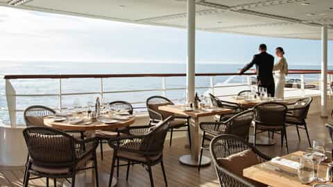Set tables on a ship deck with an ocean view - Le Bougainville, Ponant Cruises