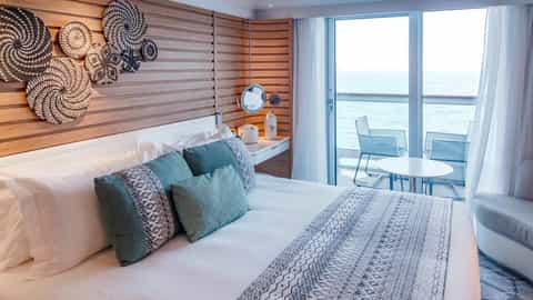 A bed and balcony with ocean view in a cruise ship suite - Le Champlain, Ponant Cruises