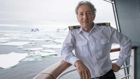 A captain stands on a ship's deck in Antarctica - Le Commandant Charcot, Ponant Cruises