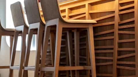Wooden bar with stools and bottles on the counter - Le Laperouse, Ponant Cruises