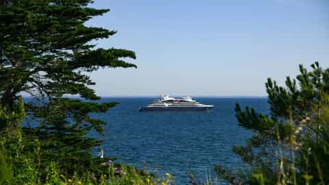 A ship sails on the blue ocean under a clear sky - Le Ponant, Ponant Cruises