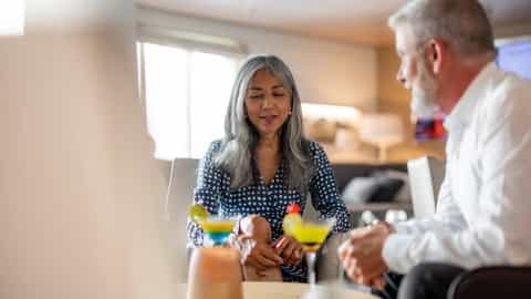 A couple enjoys cocktails in a lounge - Le Soleal, Ponant Cruises