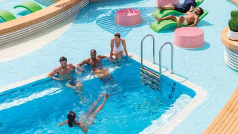 People swim and relax on a modern cruise ship pool deck - Liberty Of The Seas, Royal Caribbean