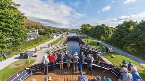 Passengers watch a canal lock from the deck of a ship - Lord of the Glens, Lindblad Expeditions
