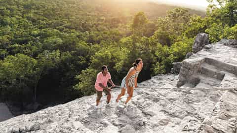 A couple climbs ancient stone steps with a rope - Mariner Of The Seas, Royal Caribbean