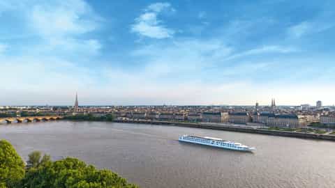 A river ship sails past a European city - ms Cyrano de Bergerac, CroisiEurope