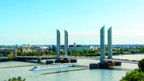 A river ship sails under a modern bridge - ms Cyrano de Bergerac, CroisiEurope