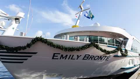 A river cruise ship is docked with festive garland - MS Emily Bronte, Riviera Travel