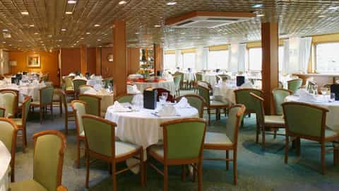 A dining room with tables set for a meal - ms Fernao de Magalhaes, CroisiEurope