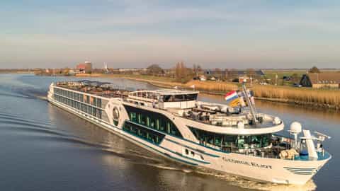 A river cruise ship sails on a calm waterway - MS George Eliot, Riviera Travel
