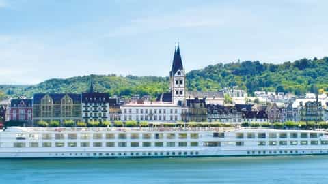 A white river ship sails past a European town - ms Gerard Schmitter, CroisiEurope