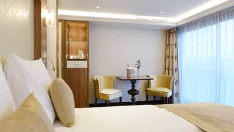 A suite sitting area with a table and champagne - MS Jane Austen, Riviera Travel